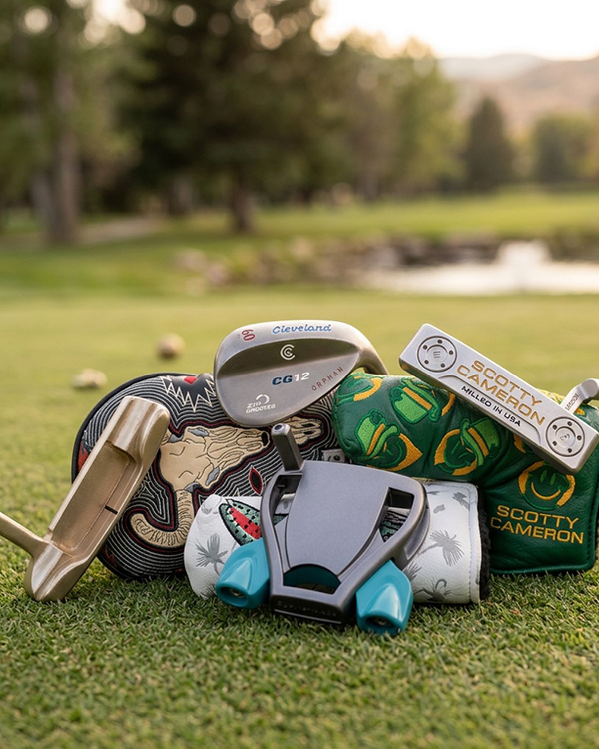 Custom wedges, putters and headcovers arranged on a fairway at a Colorado golf course
